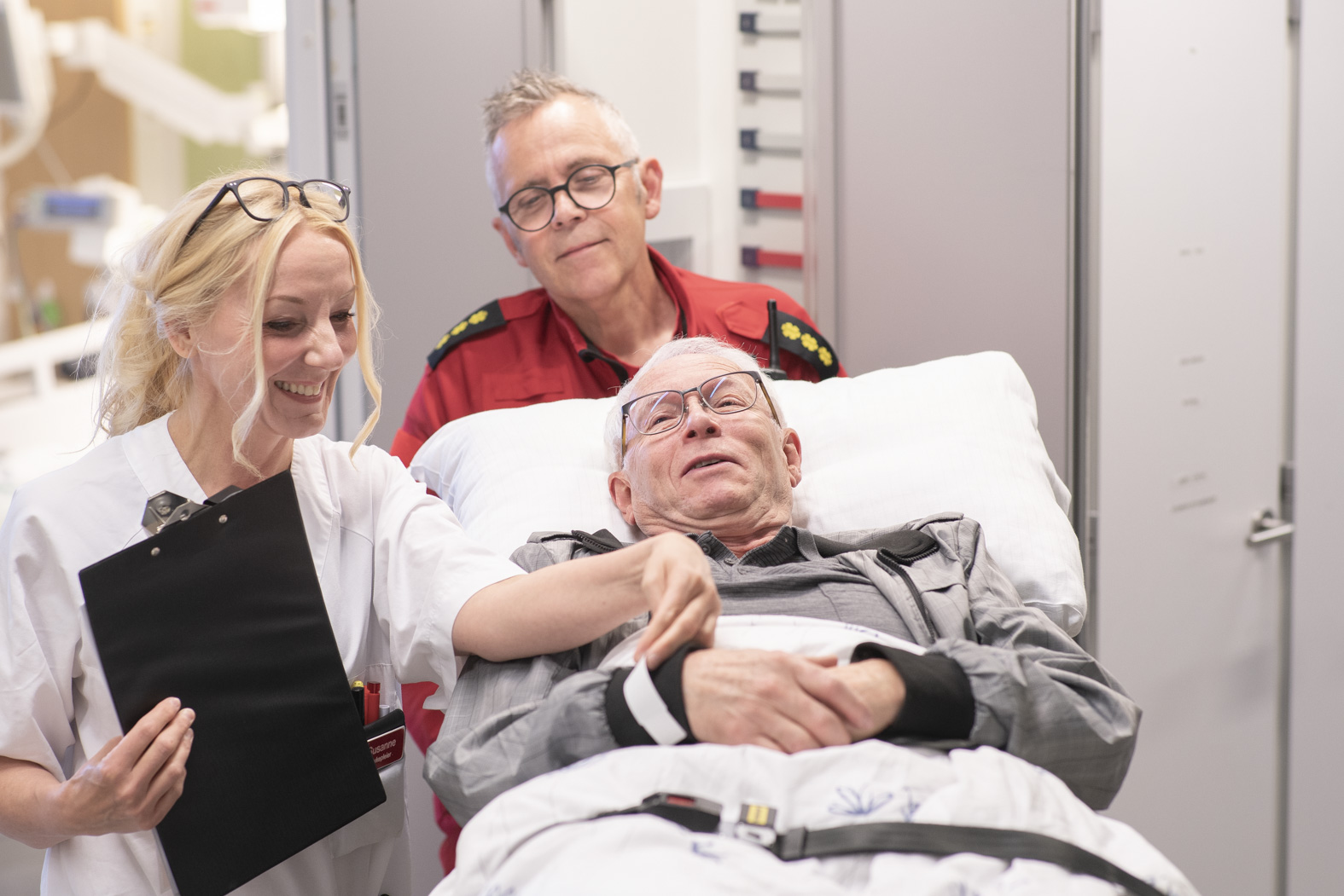 En gruppe mennesker som står rundt en person i en sykehusseng