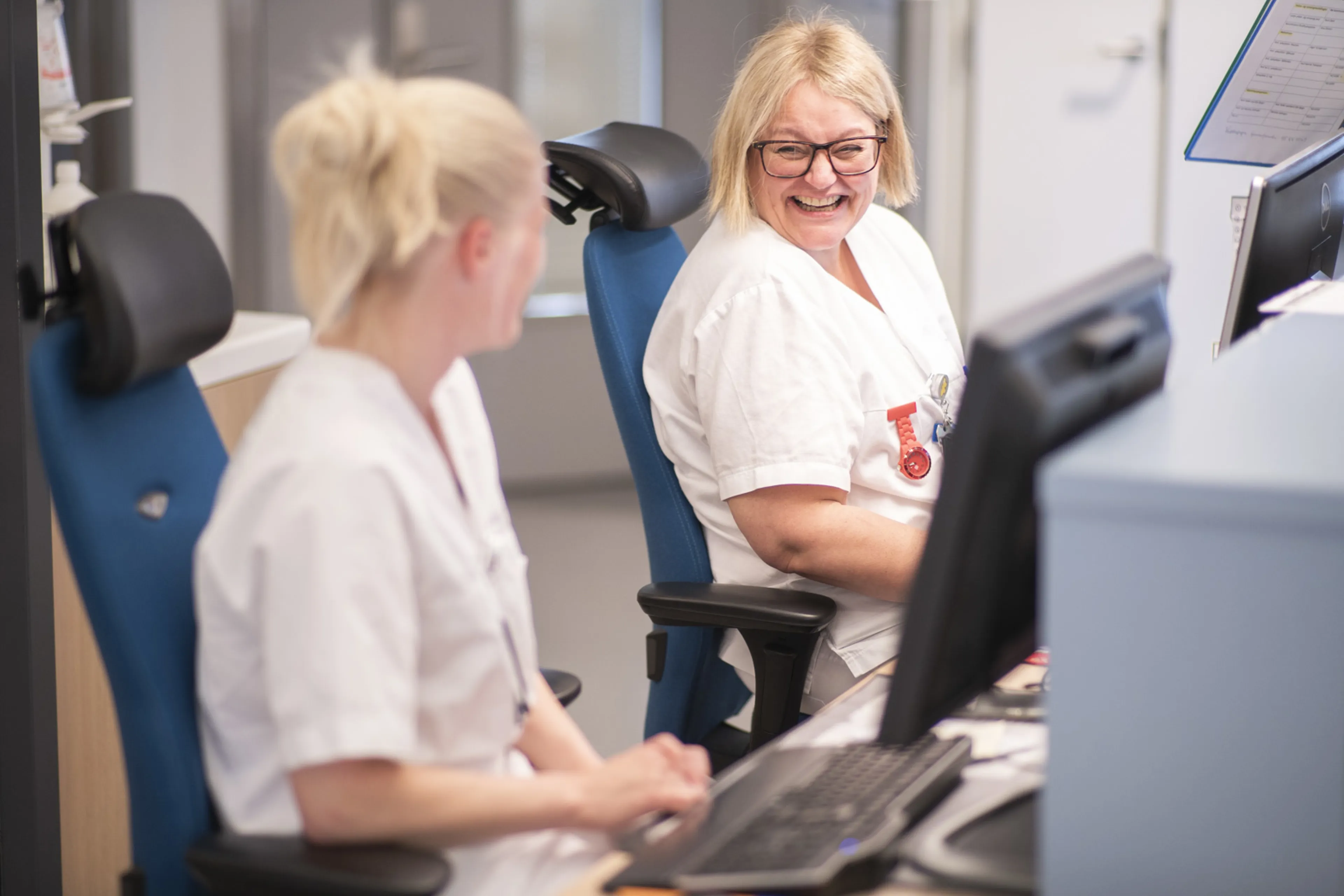 En person som viser en person noe på datamaskinen