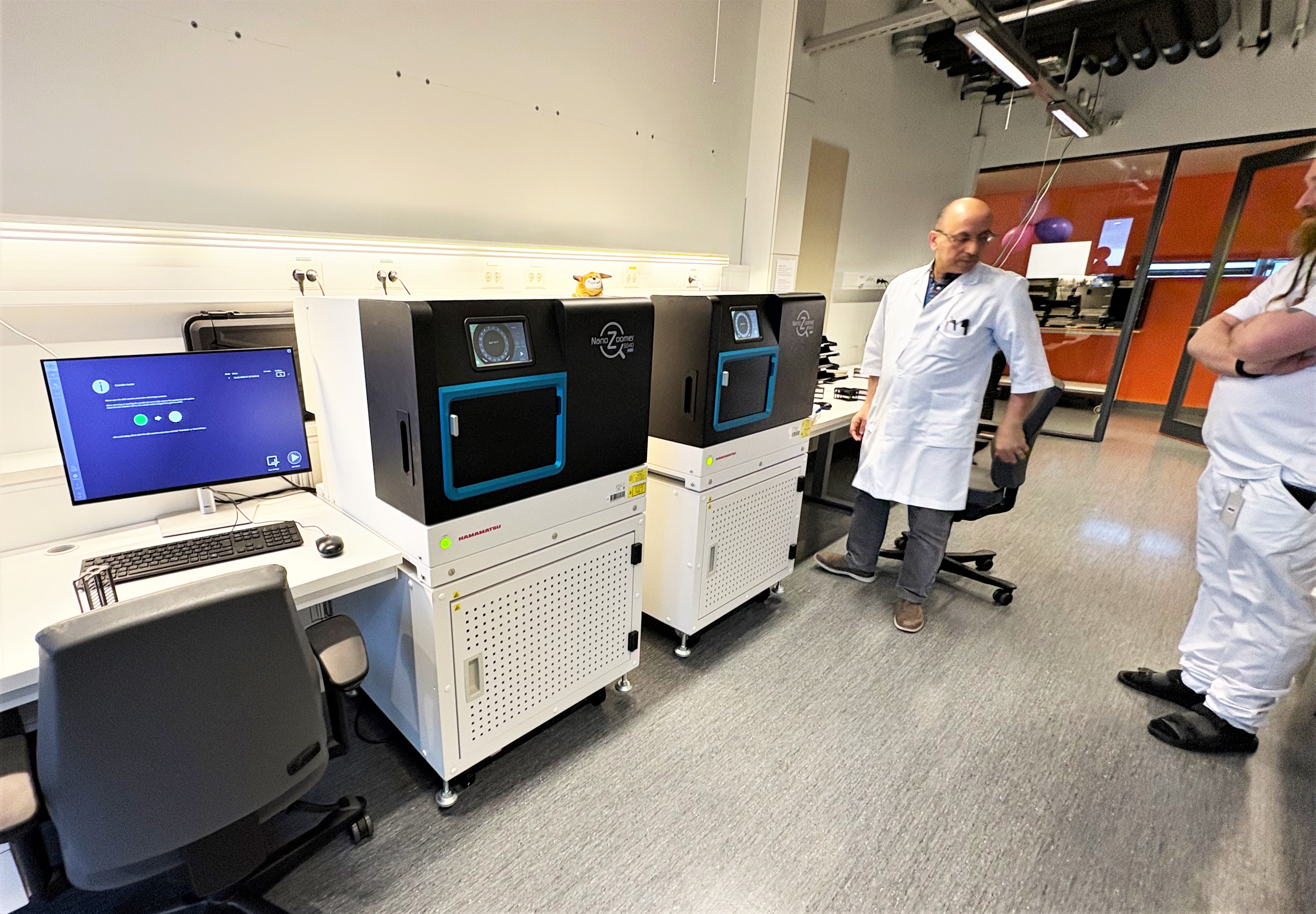 Et par menn i et rom med datamaskiner og stoler