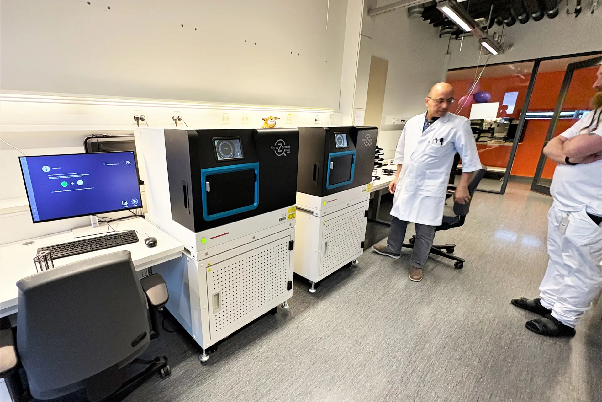 Et par menn i et rom med datamaskiner og stoler