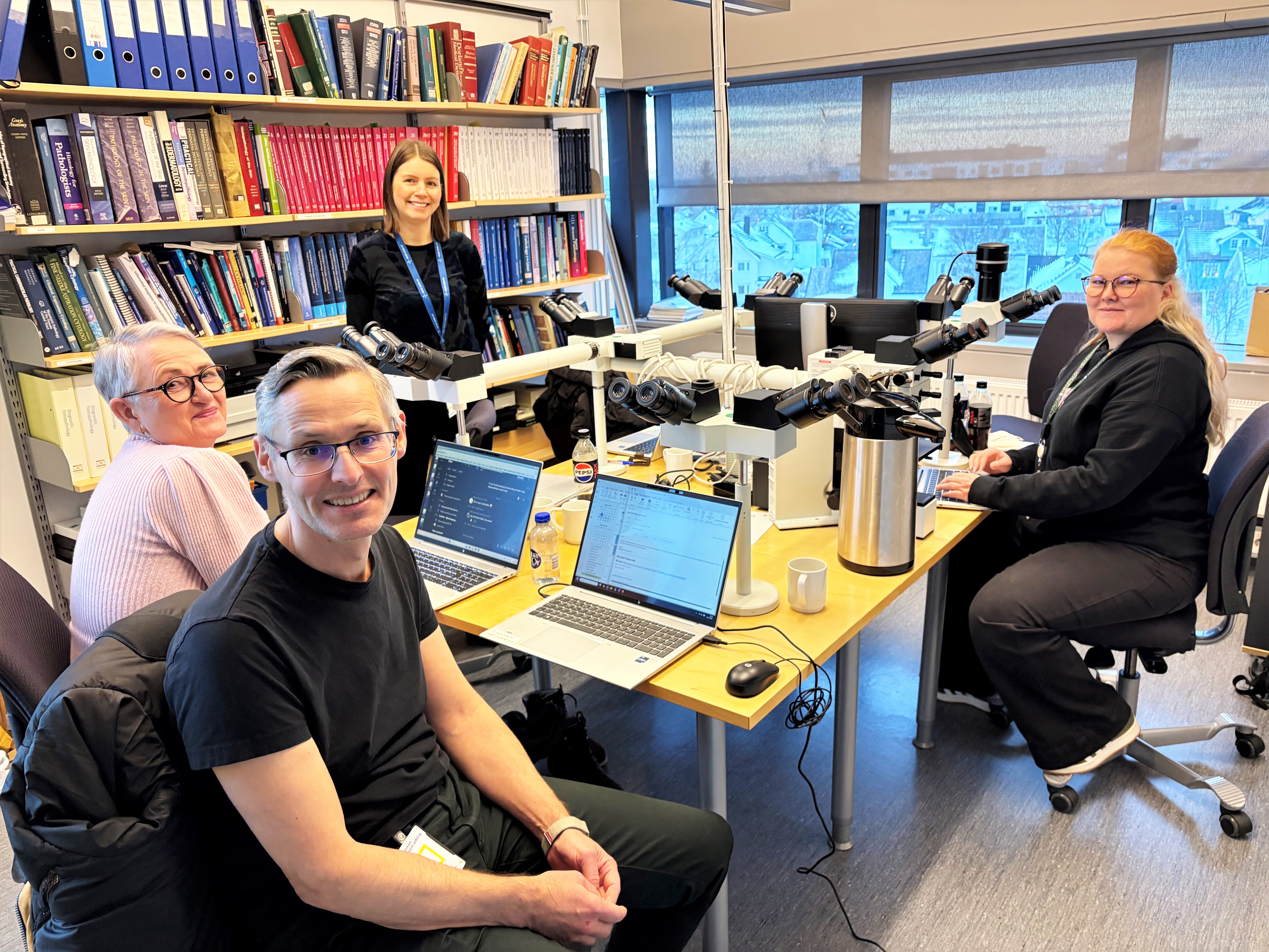 En gruppe mennesker som sitter i et rom med pcer