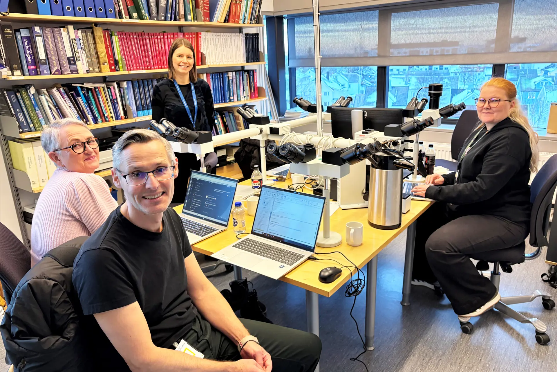 En gruppe mennesker som sitter i et rom med pcer