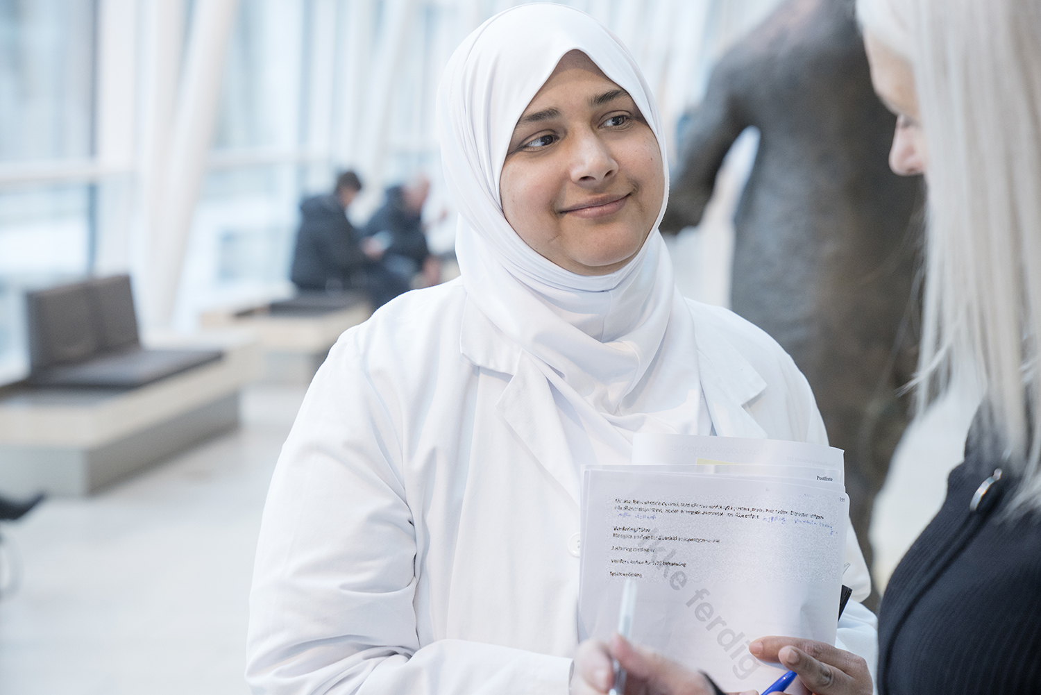 Dame med hijab prater med kollega