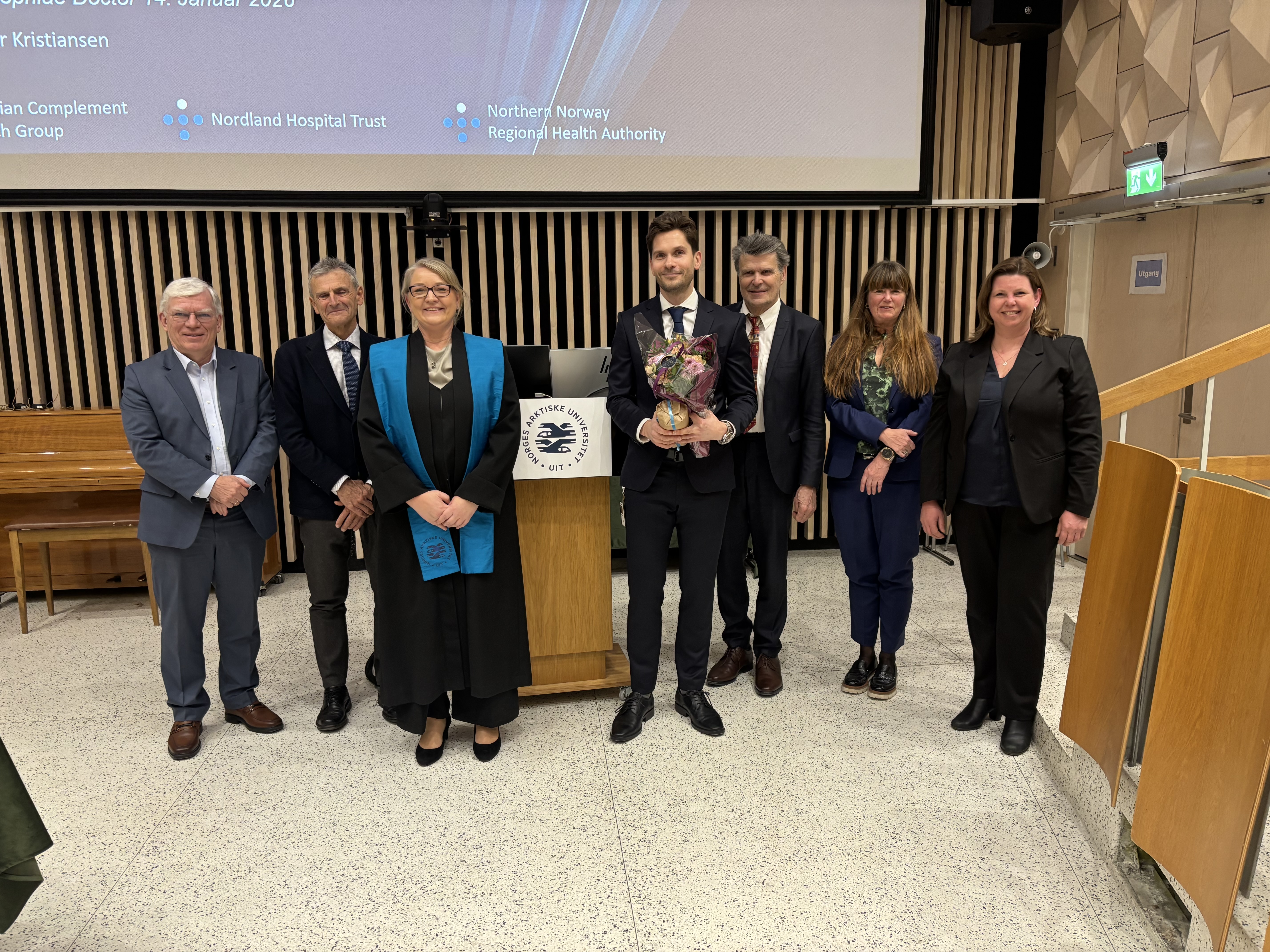 Gruppe mennesker som står samlet og smiler