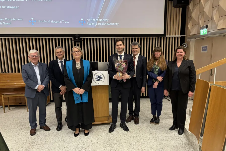 Gruppe mennesker som står samlet og smiler