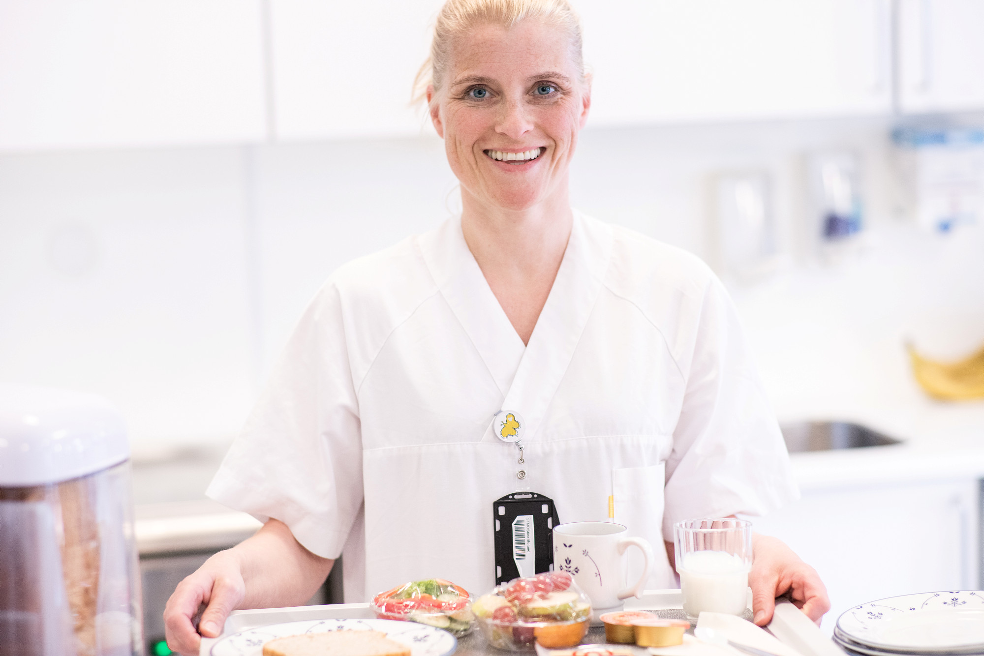 Kvinnelig sykepleier som holder matbrett