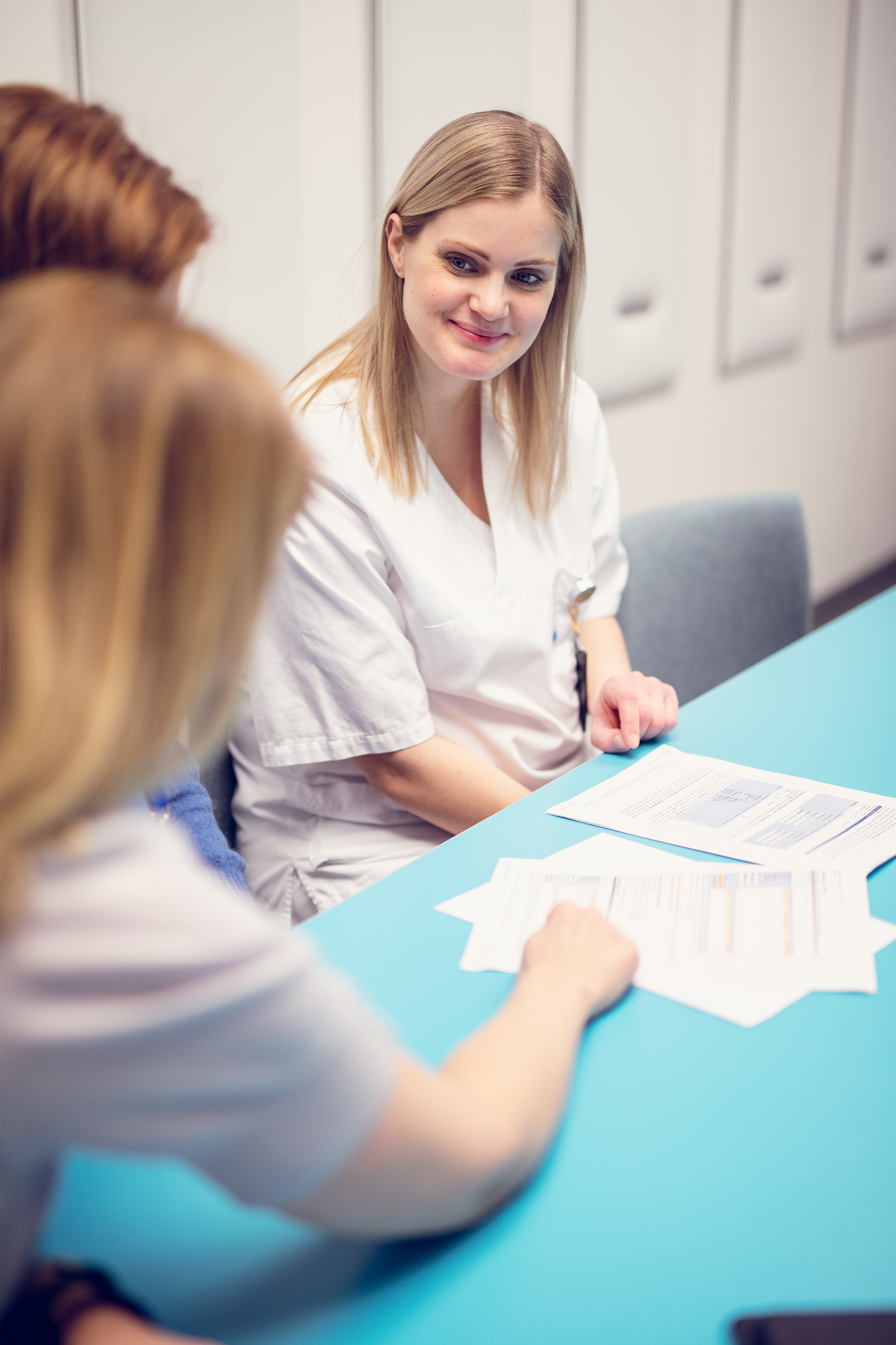 Dame som sitter ved et bord og smiler