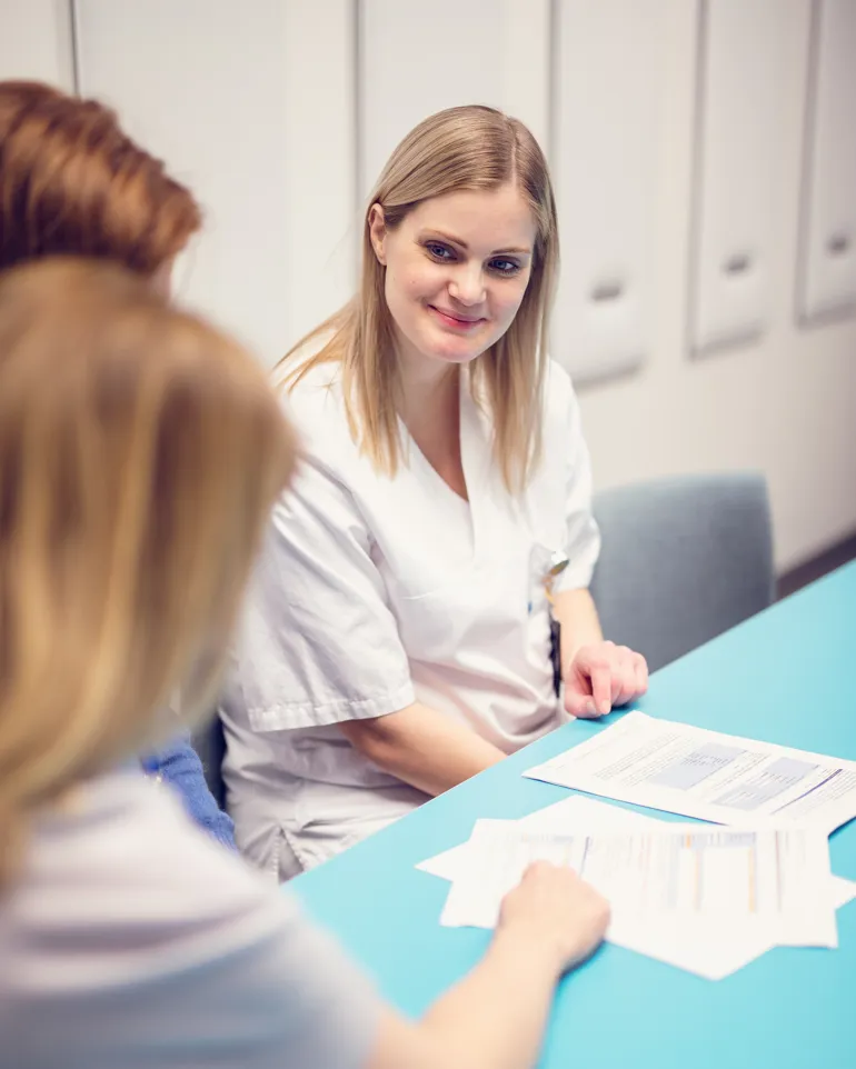 Dame som sitter ved et bord og smiler