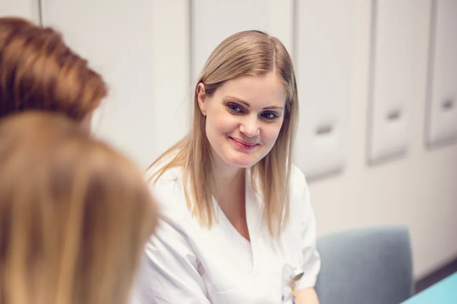 Dame som sitter ved et bord og smiler