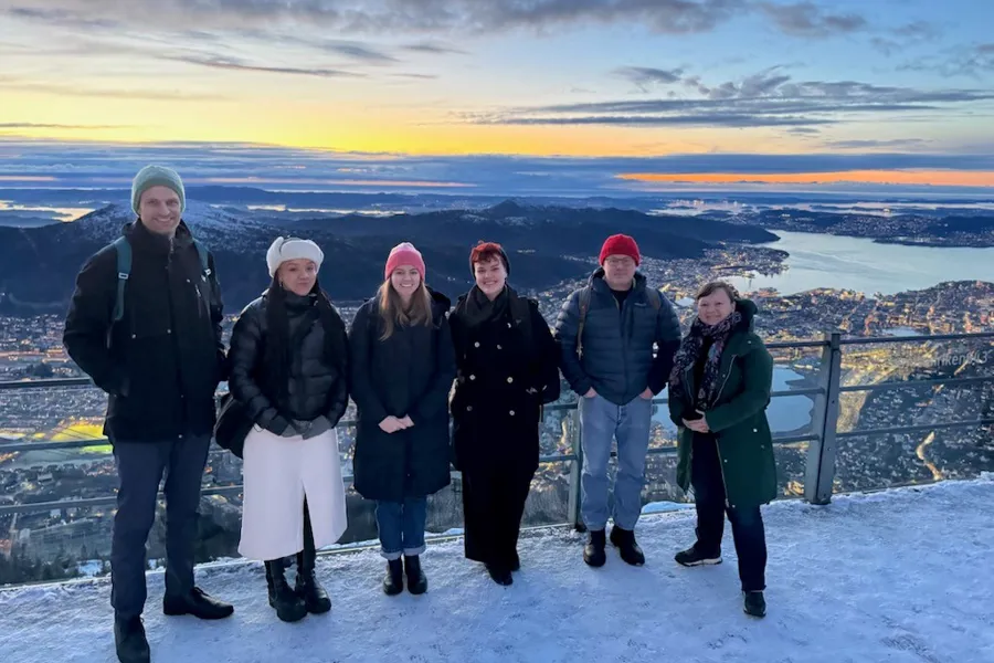 En gruppe mennesker som poserer for et bilde på et snødekt fjell