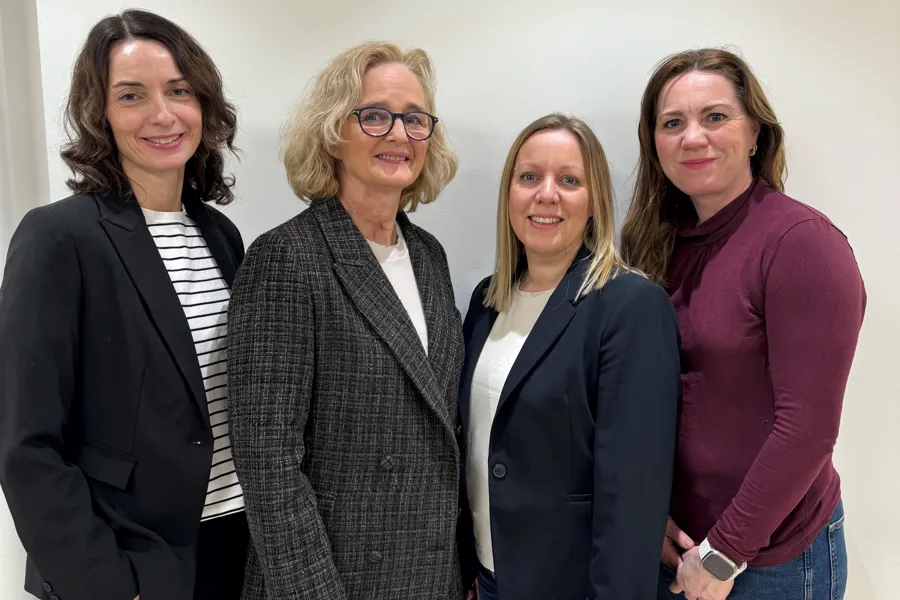 Fire kvinner står samlet og smiler