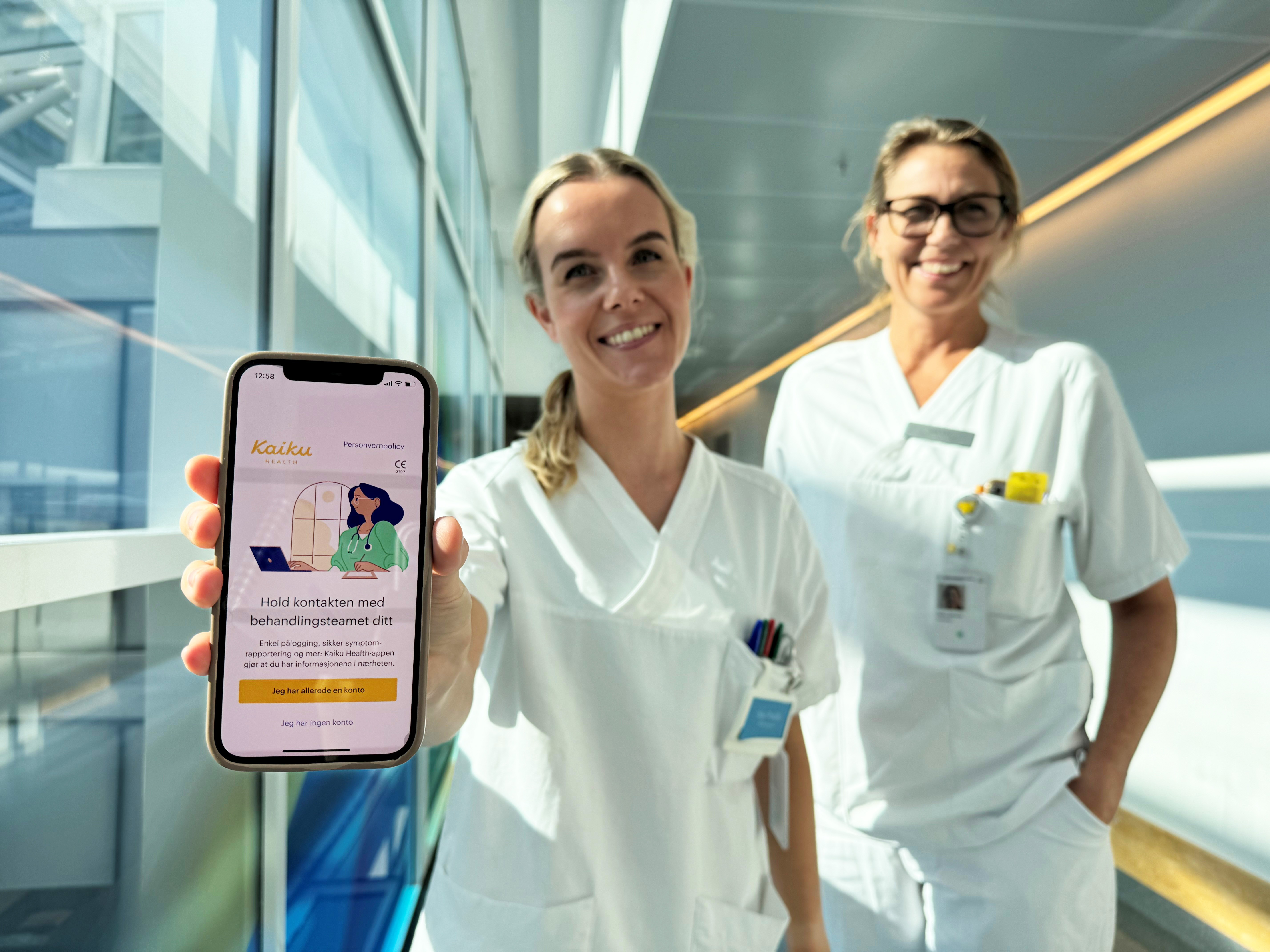 Et par kvinner i hvite frakker som holder en tavle