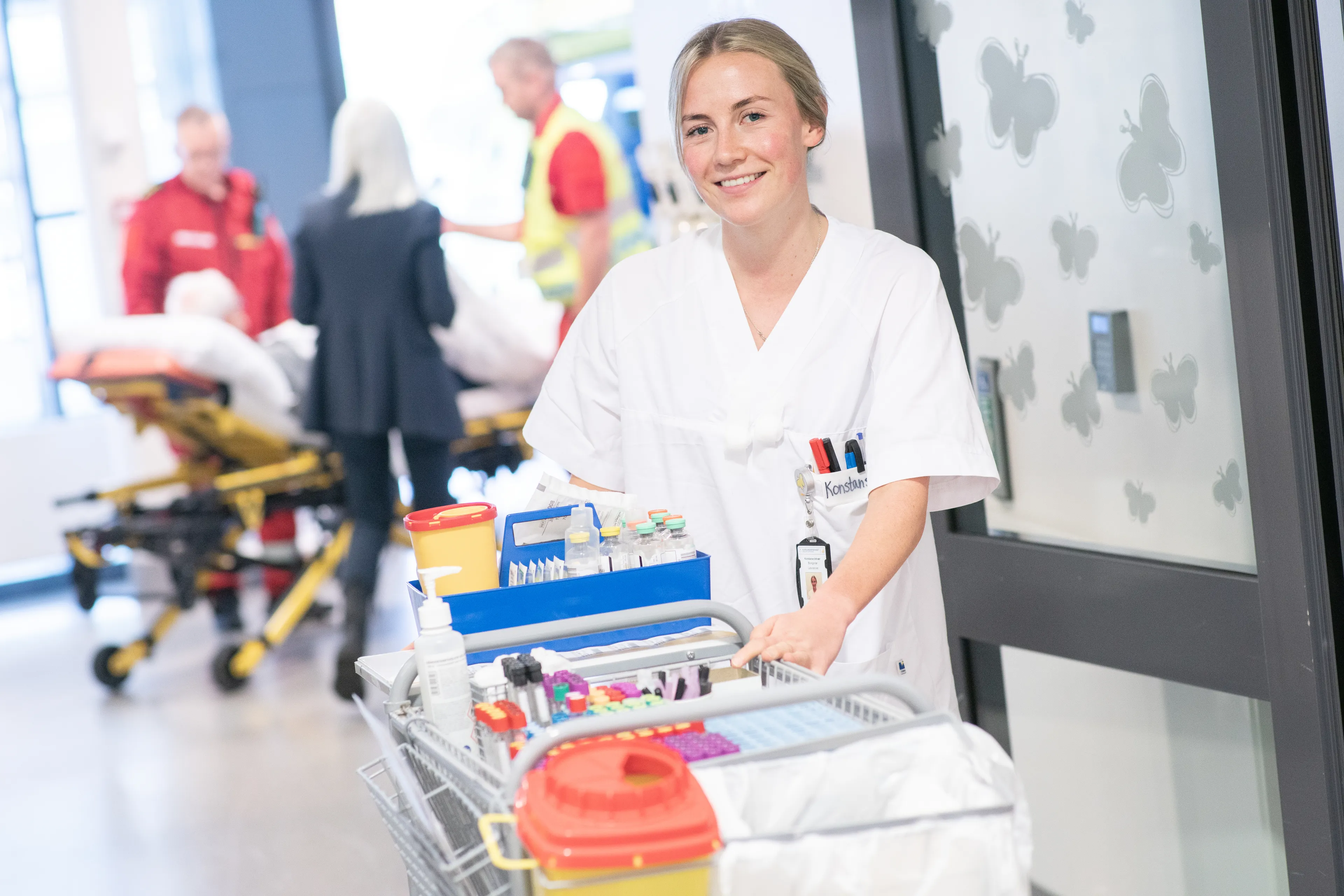 Sykepleier som står i døråpningen til pasientrom