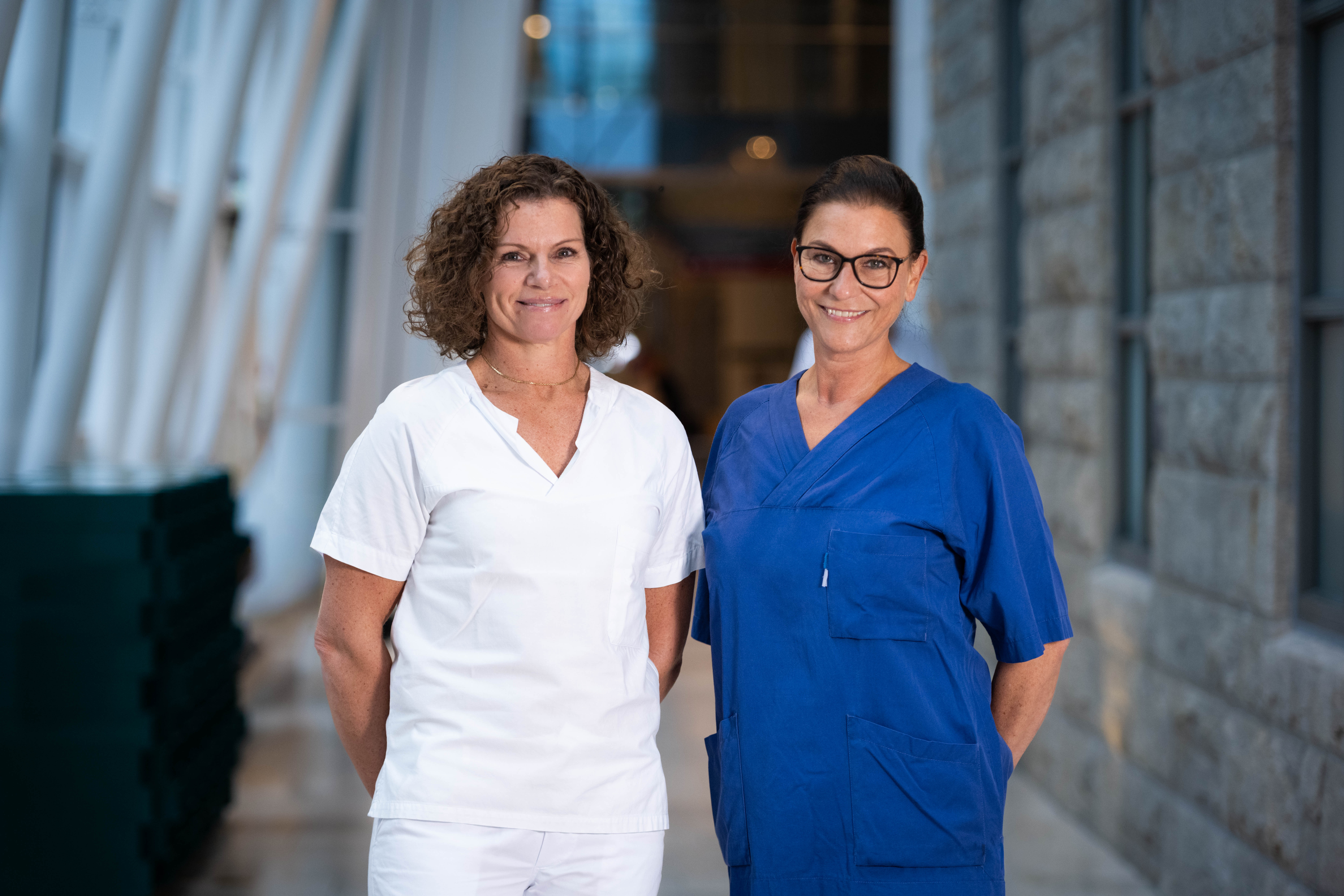 To kvinner som står ved siden av hverandre og smiler