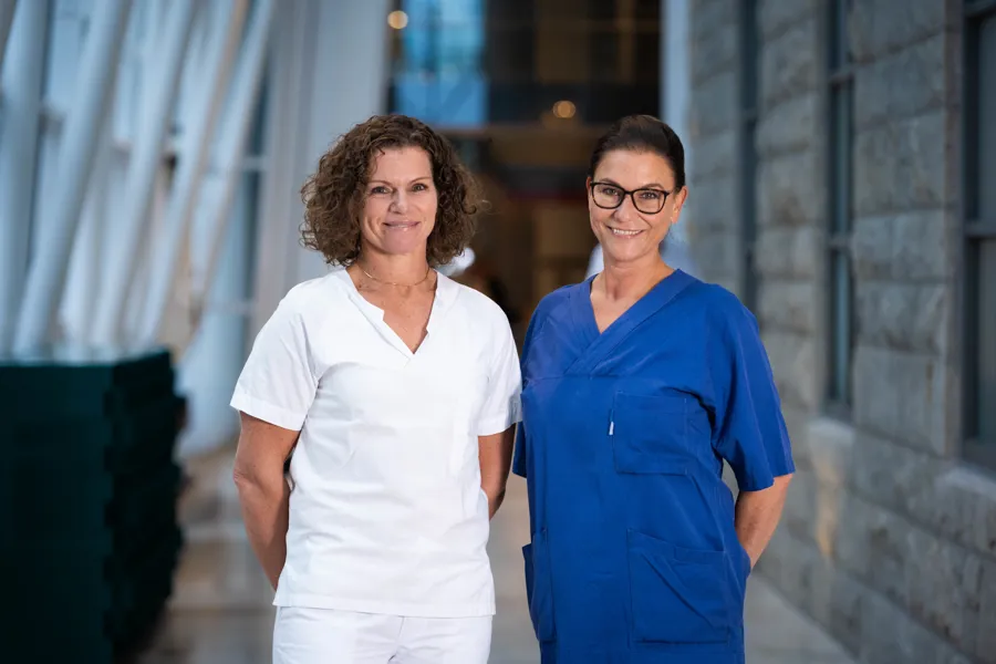 To kvinner som står ved siden av hverandre og smiler