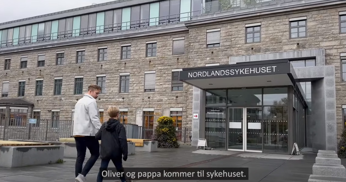 Far og sønn går mot inngangen til sykehus