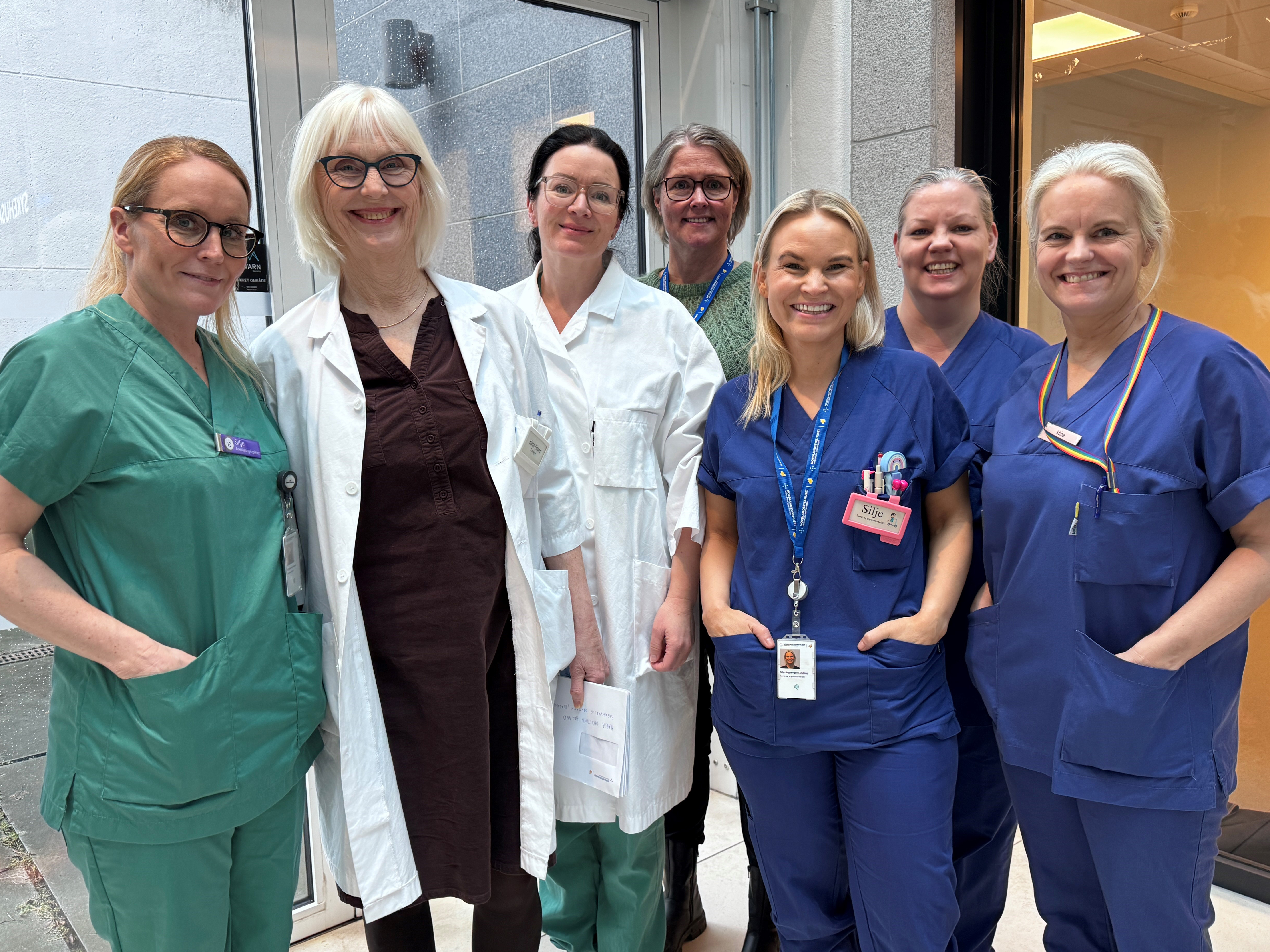 En gjeng med kvinner som står samlet og smiler