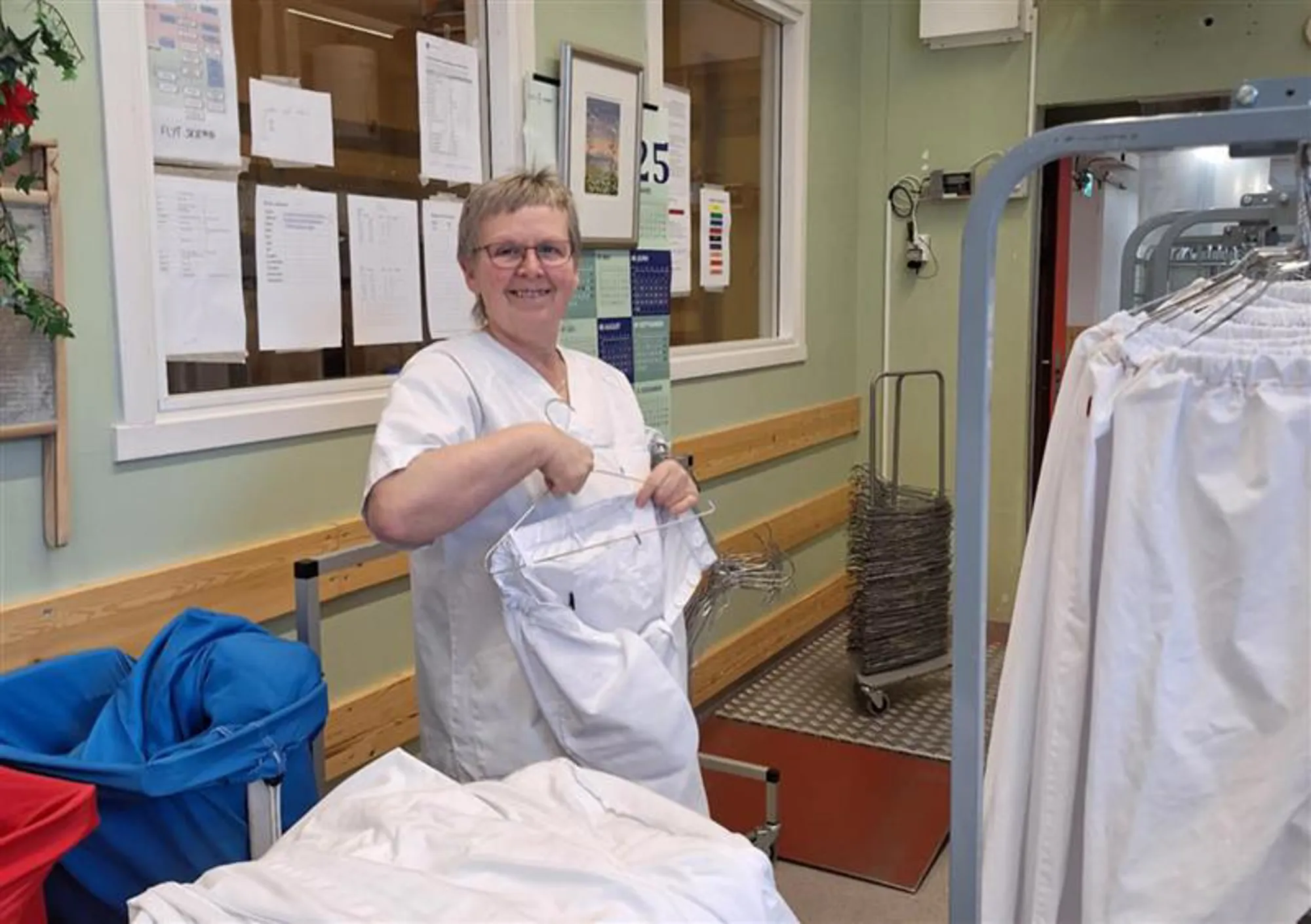 Dame som henger opp klær på stativ