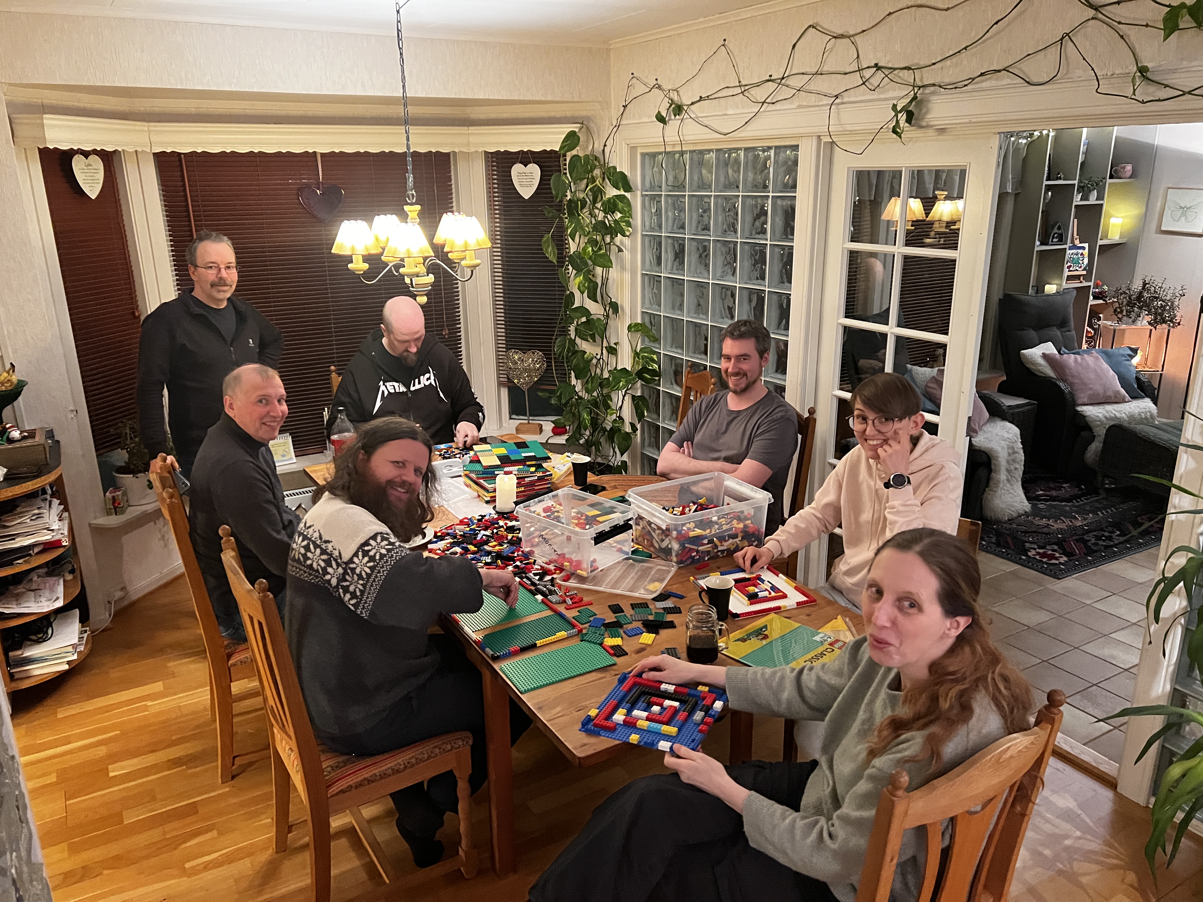En gruppe mennesker som sitter rundt et bord med lego