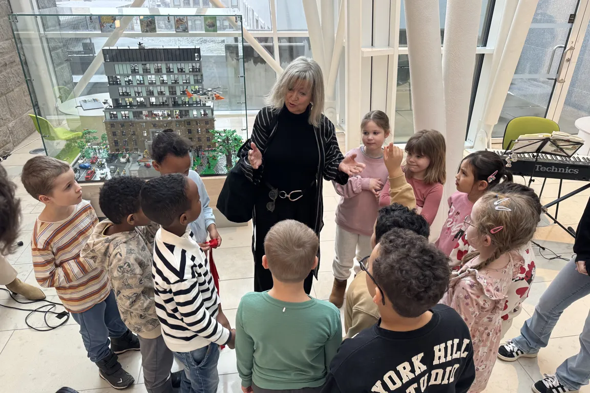 Dame som snakker til en liten gjeng med barn