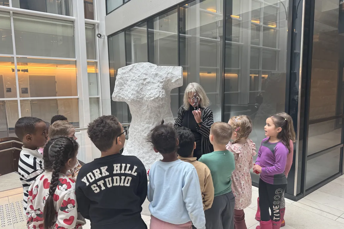 Dame som snakker til en gruppe barn