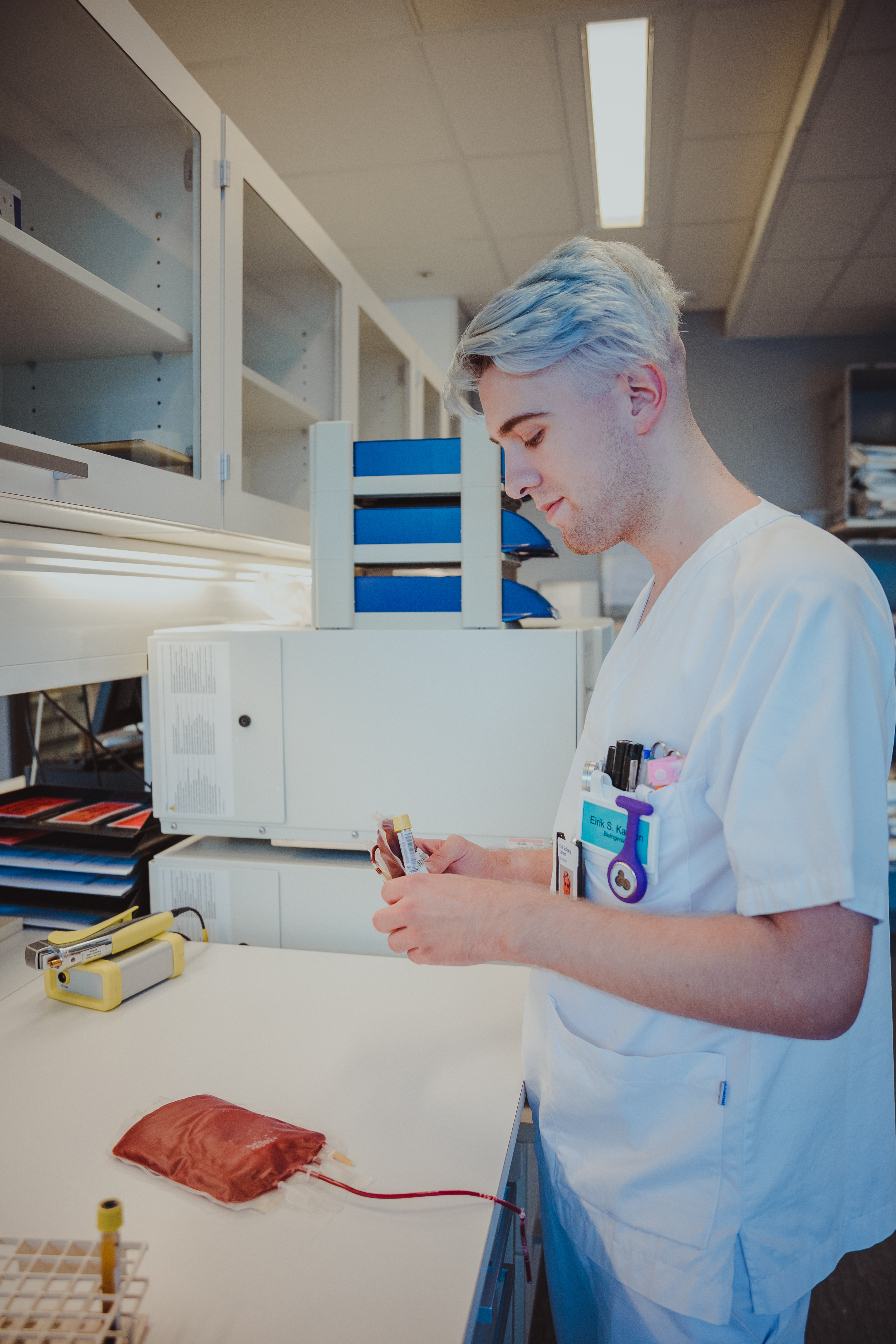 Mann som holder noen blodprøveglass på et laboratorie