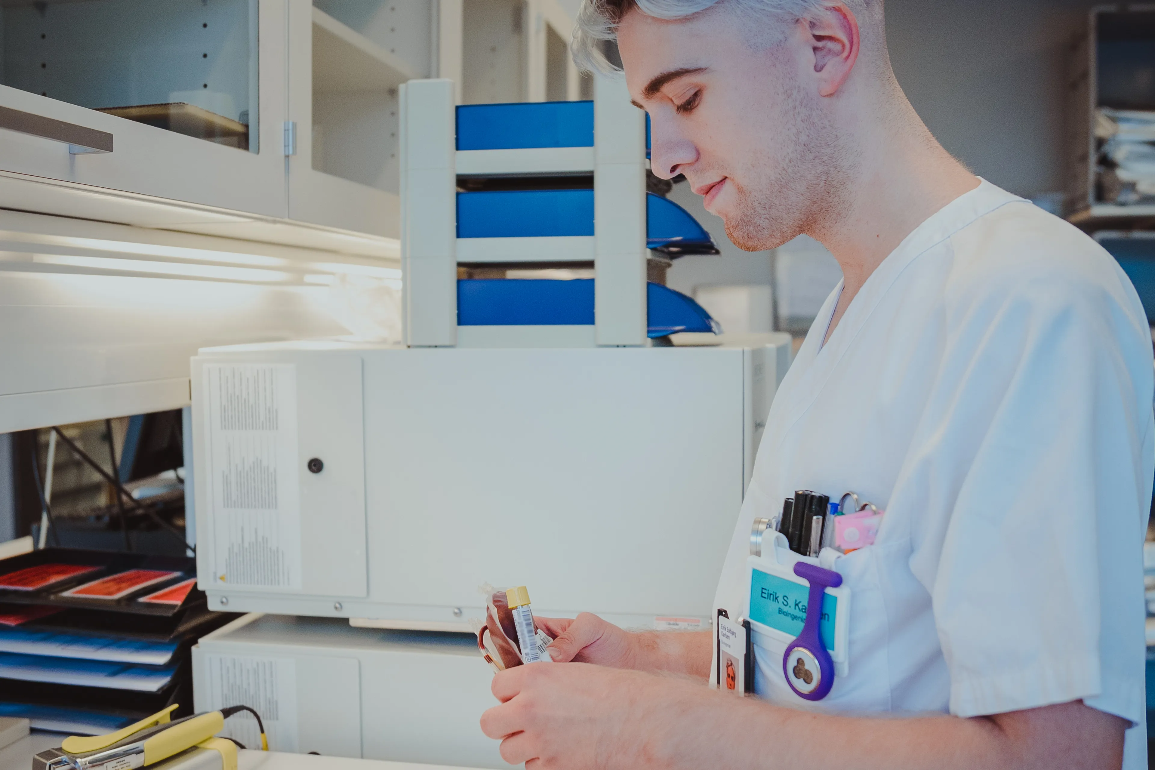Mann som holder noen blodprøveglass på et laboratorie