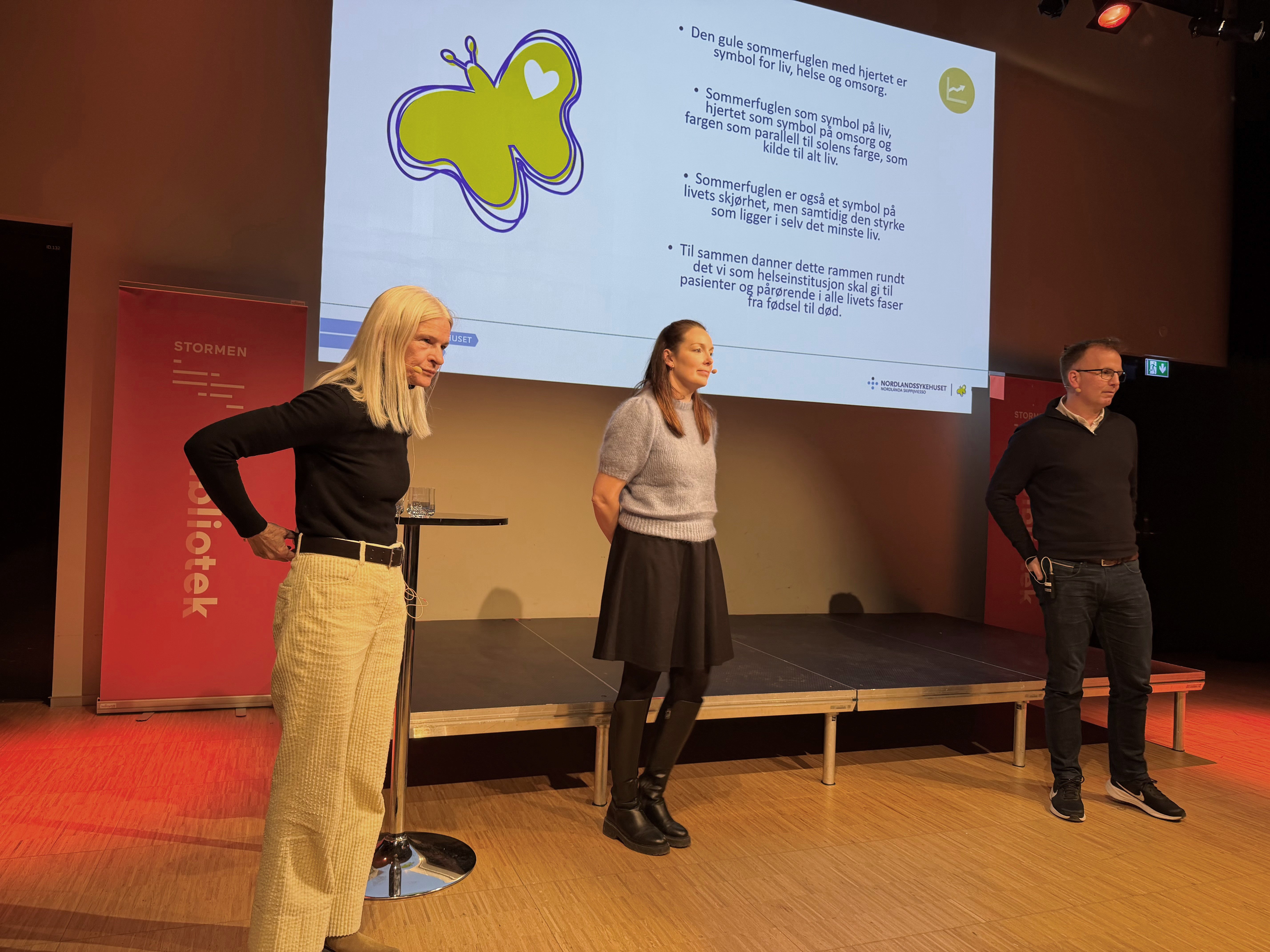 En gruppe mennesker som står foran en skjerm