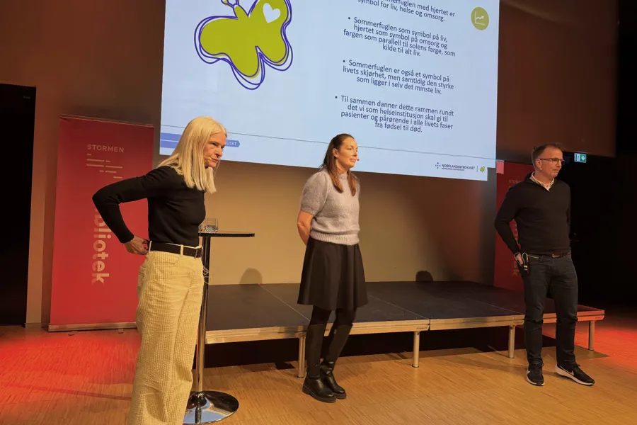 En gruppe mennesker som står foran en skjerm