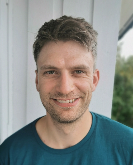 En mann som smiler til kameraet