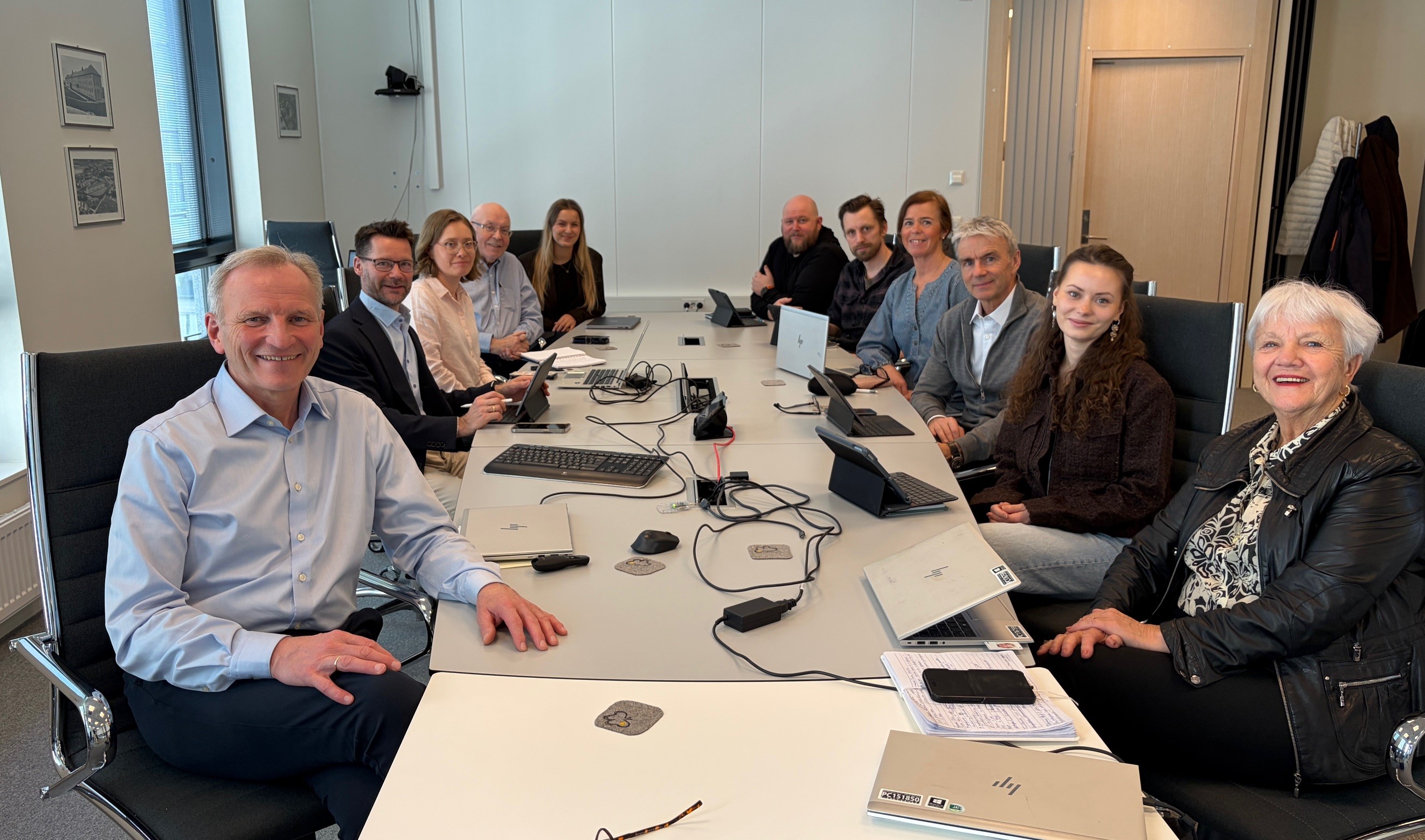 En gruppe mennesker som sitter rundt et bord med bærbare datamaskiner