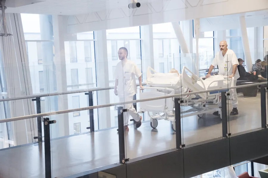 To personer som triller en sykehusseng