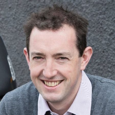 En mann som smiler til kameraet