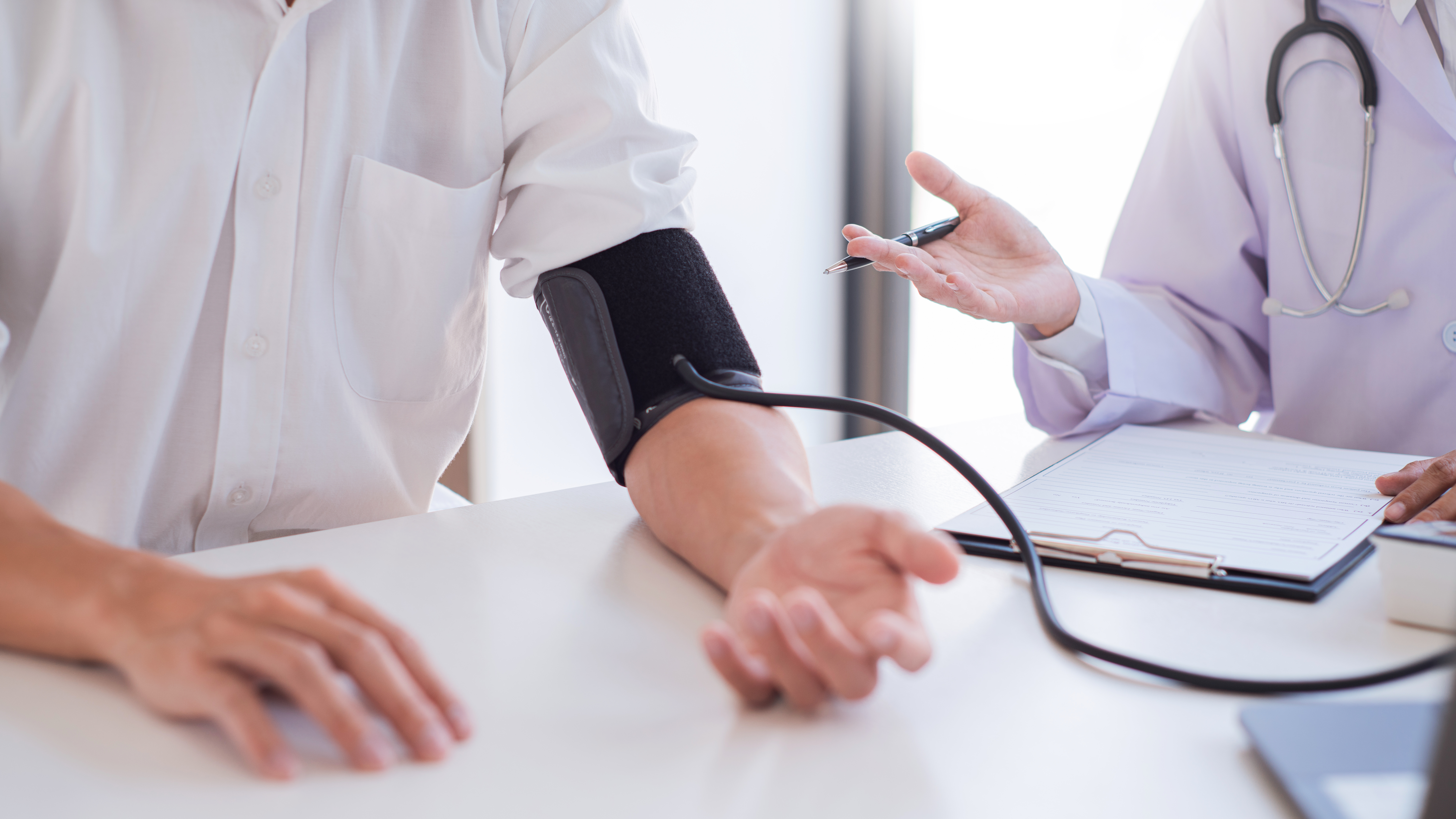 Lege som måler blodtrykk på pasient