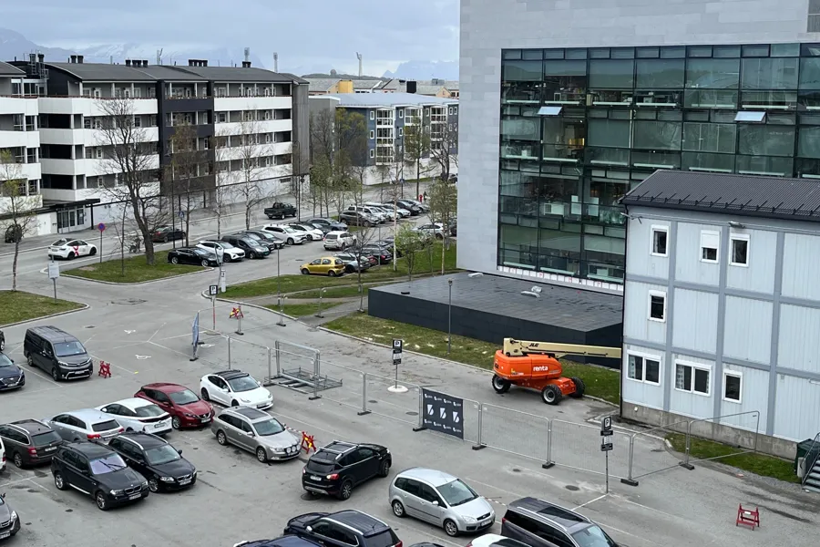 En parkeringsplass med biler og bygninger