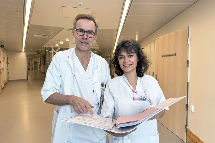 En mann og en kvinne i hvite klær som ser i en ringperm