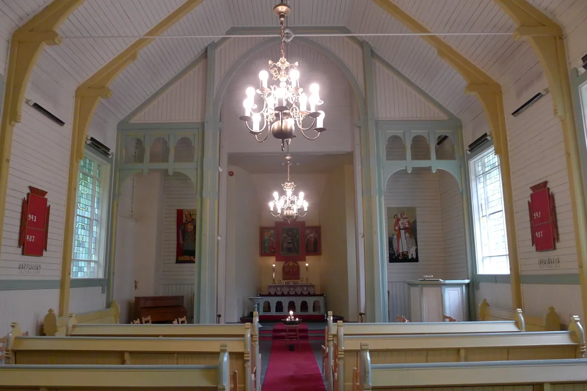 A large church with a chandelier and a red carpet