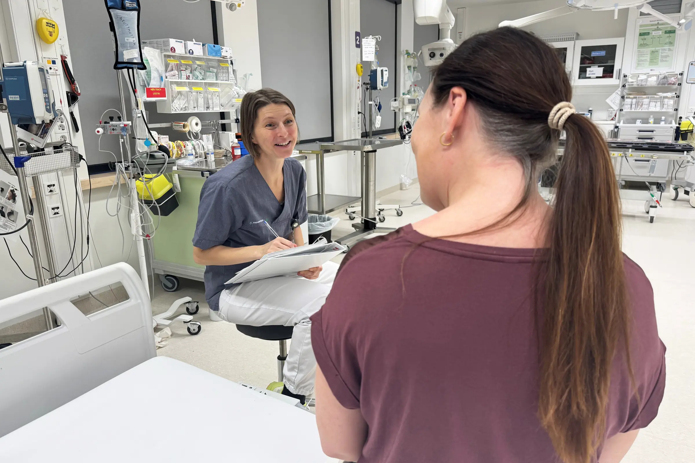 En kvinne som ser på en mann i et rom med maskiner