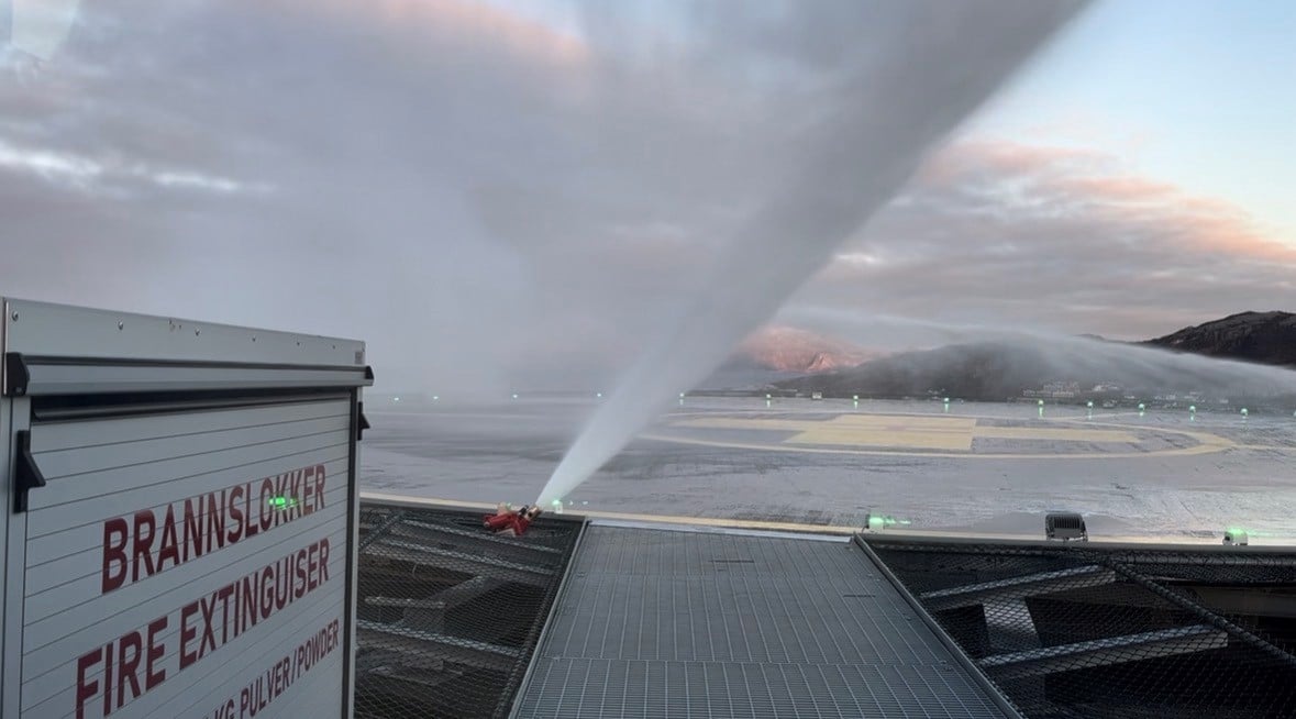 Brannslange som spruter vann på et helikopterdekk. Mye røyk
