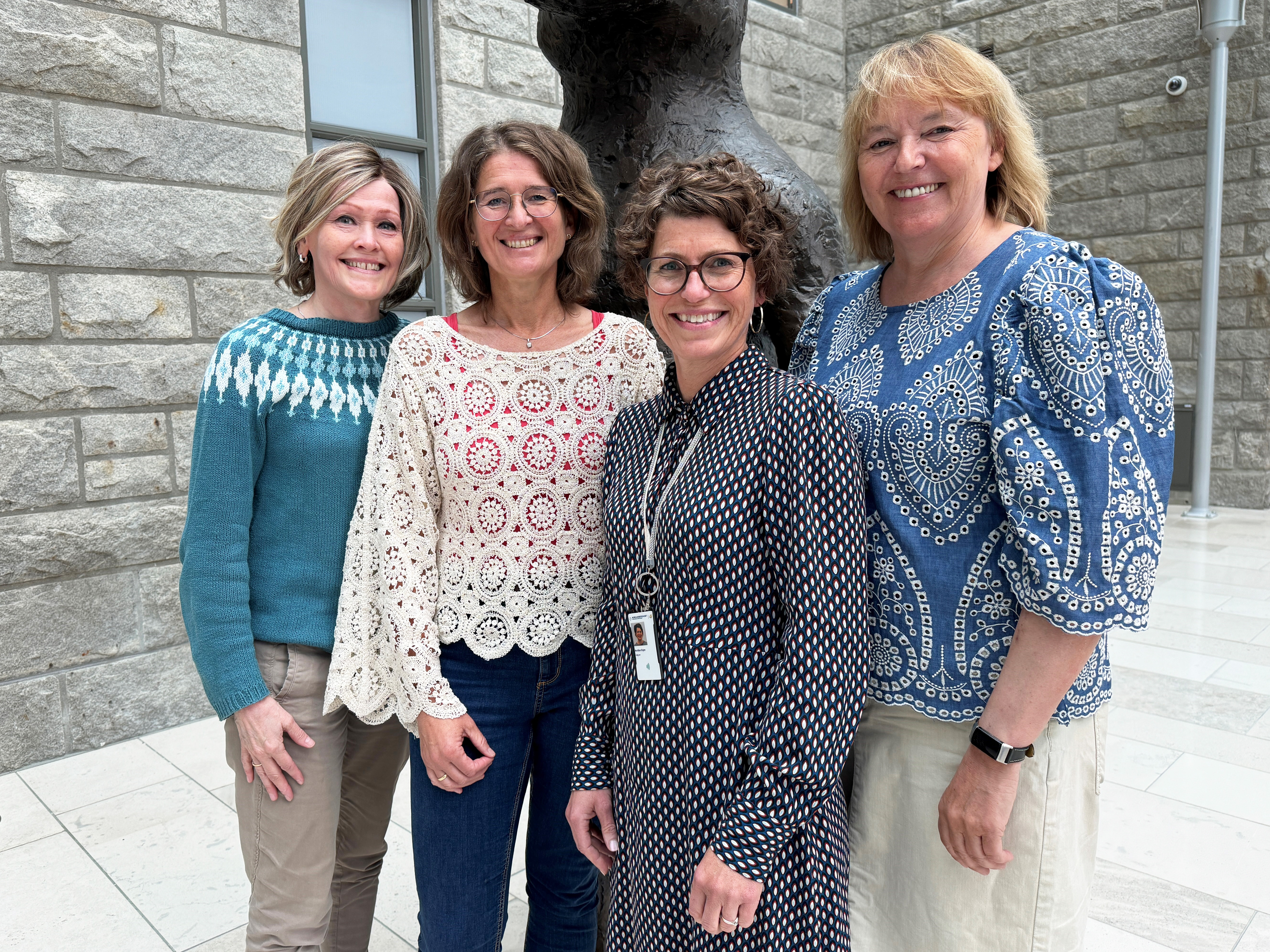 Fire damer som står samlet