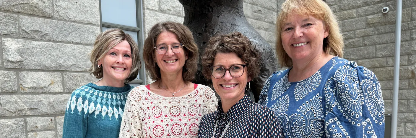 Fire damer som står samlet