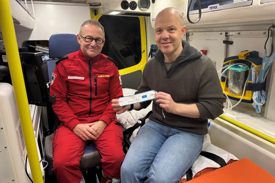 To menn sittende inni en ambulanse