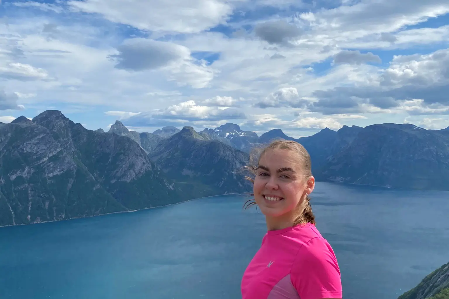 En person som står på en klippe ved en vannmasse