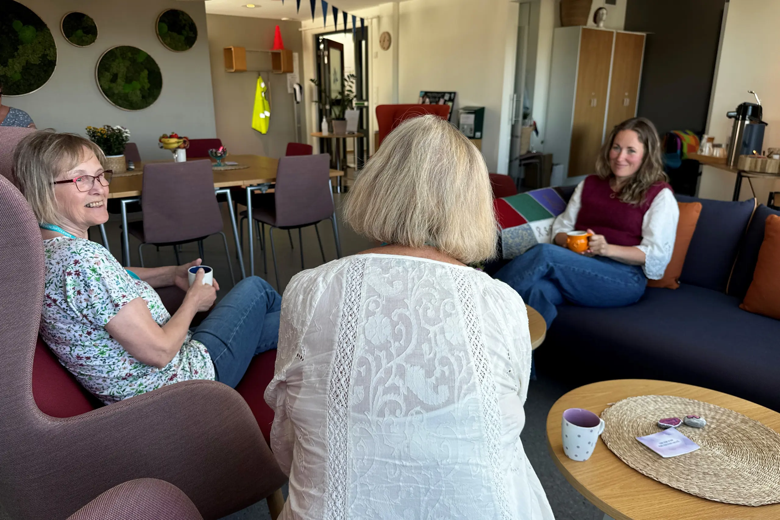 En gruppe kvinner som sitter i en stue