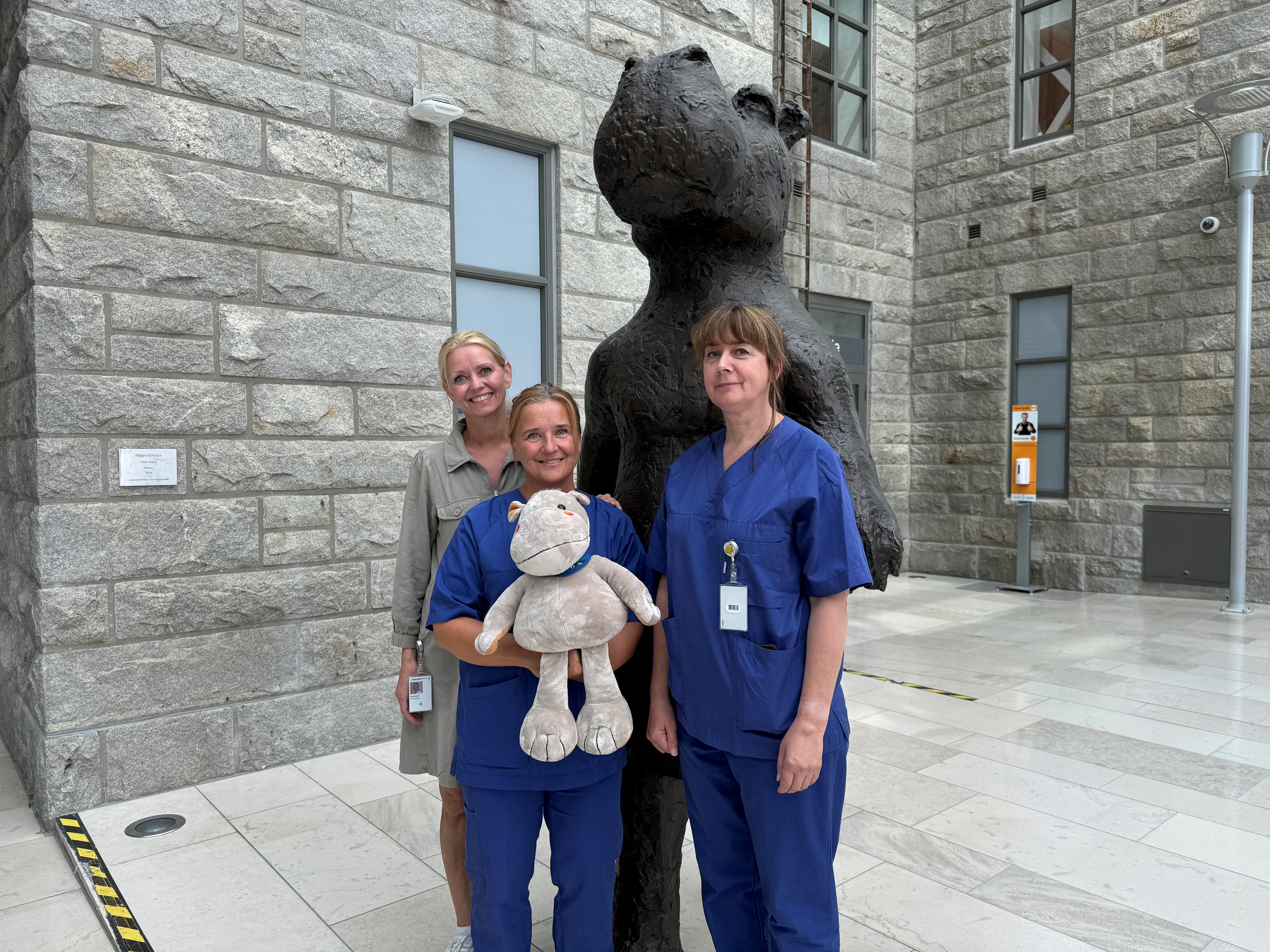 Tre damer holder en bamse