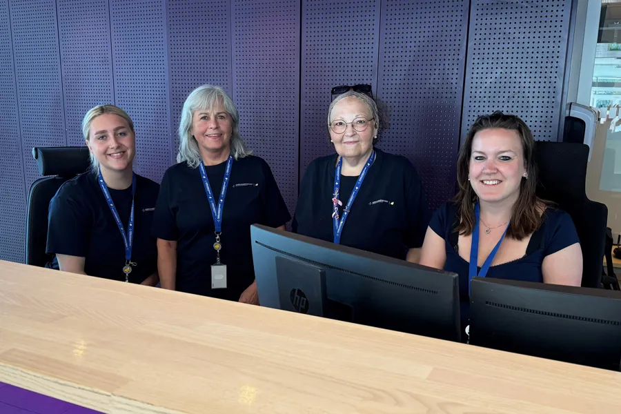 En gruppe kvinner som sitter ved et bord med en bærbar datamaskin