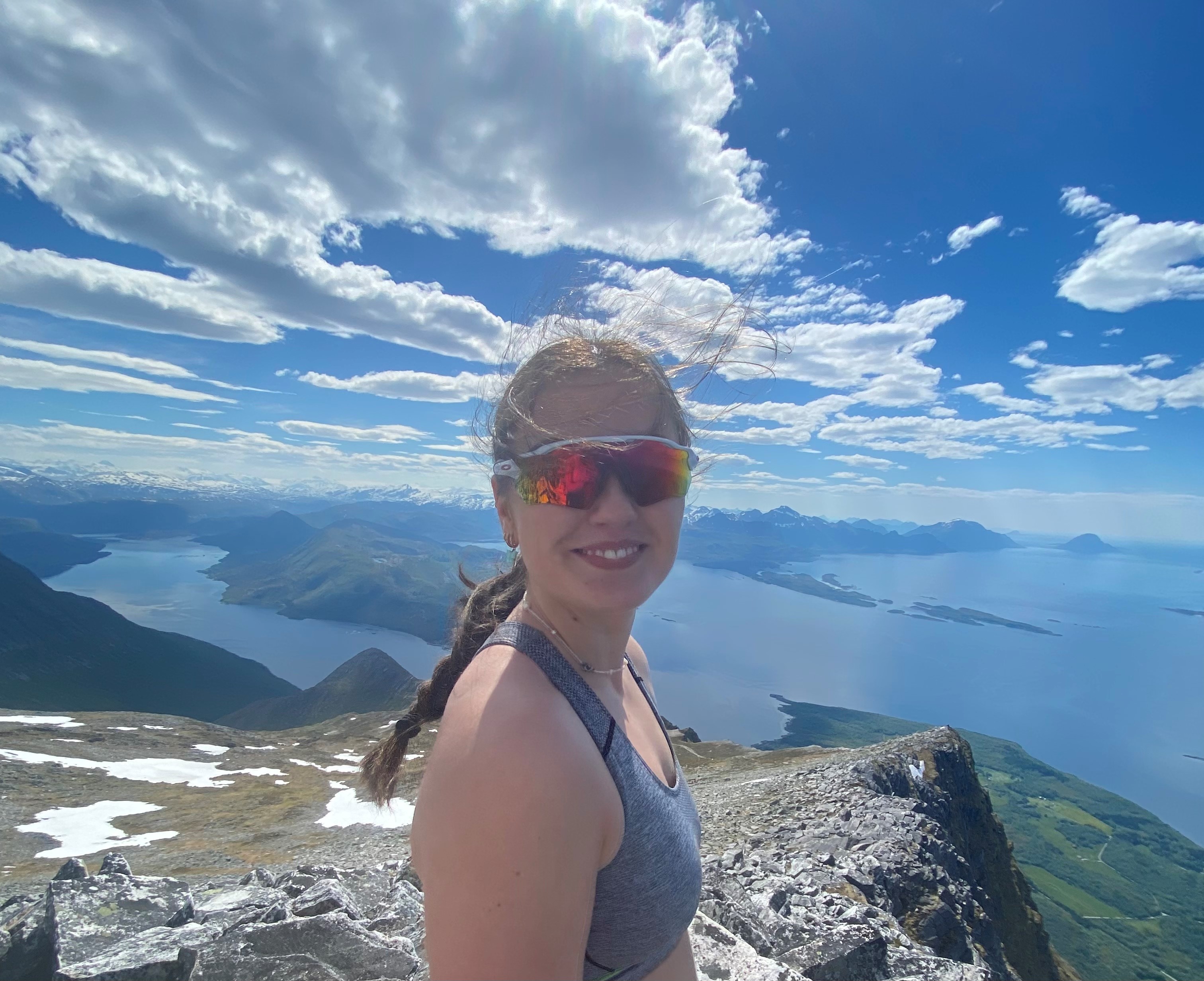 En person med rød og blå maling i ansiktet som står på et fjell