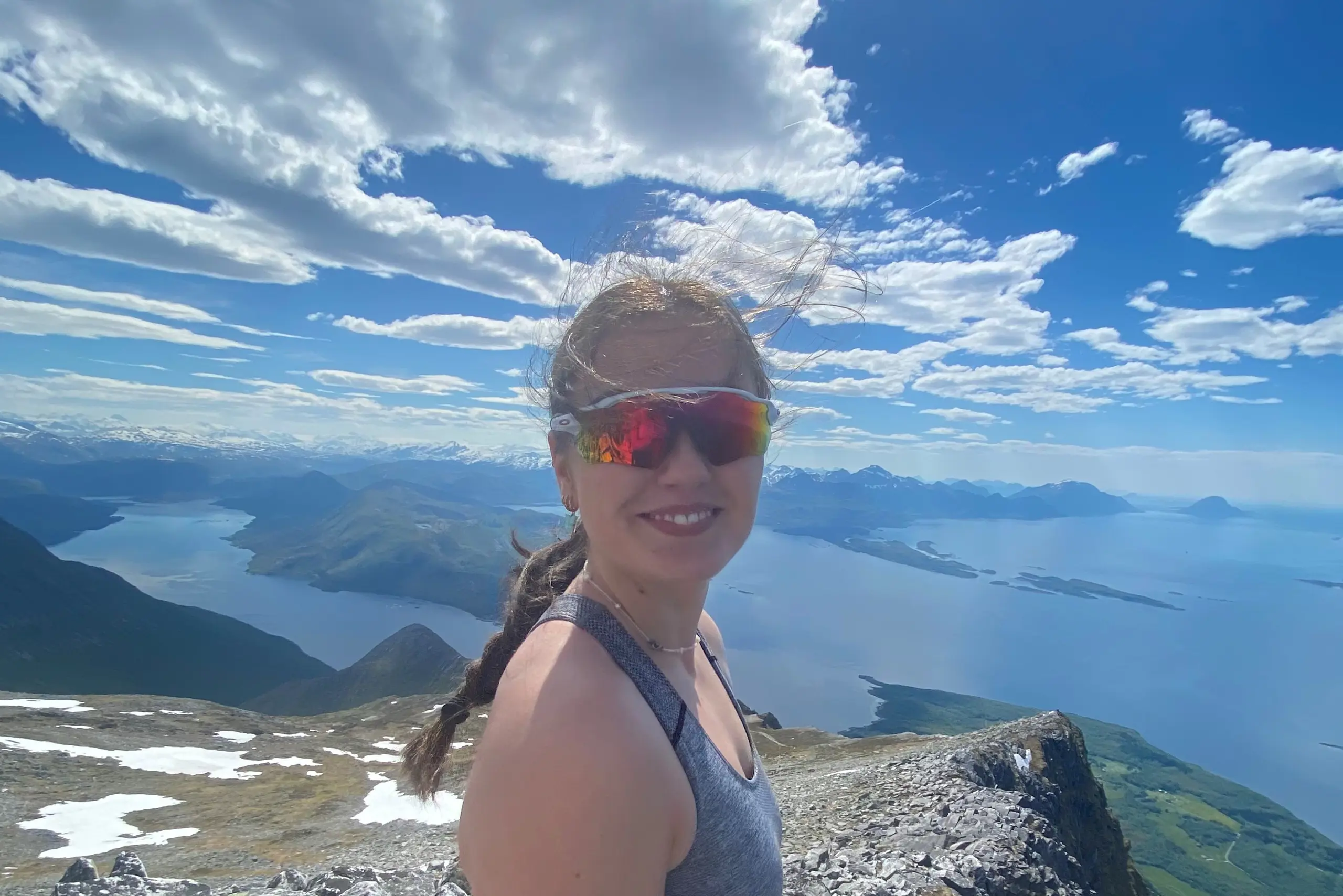 En person med rød og blå maling i ansiktet som står på et fjell