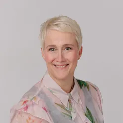 Portrettbilde av dame med kort hår som smiler