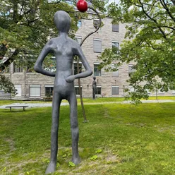 Statuer og trær i en park med grønt gress